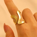 Close-up of a golden wavy irregular stainless steel open ring on a woman's index finger - Vertical Stripe Wave (6834)