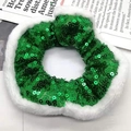 Détail du chouchou à paillettes vertes avec bordure en fourrure blanche sur journal - Vert à paillettes