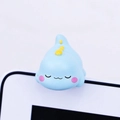 Detailed view of a cute blue resin dinosaur ornament resting on a white monitor screen - Dinosaur Monitor Hanger