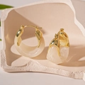 Dettaglio di orecchino vintage in resina su base in pietra con accenti in metallo dorato - Bianco