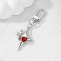 Silver shooting star keychain with a red heart crystal pendant on white textured background - Red Rhinestone Heart