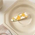 Detailed close-up of yellow and white flower acrylic hair clip on ceramic plate - Yellow with Large Yellow Flowers