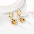 Dettaglio di orecchini a cuore dorati con zirconi bianchi su uno sfondo bianco - Stile Cuore Oro / Oro
