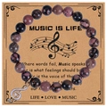 Gros plan de perles en pierre zèbre rose de 8mm et d'une breloque note de musique dorée - Rhodonite avec Lignes Noires