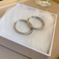 Silver-plated hoop earrings with sparkling zircon inlay shown on white faux fur background - Thick Hoop (19#)
