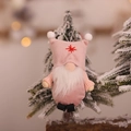 Pink Nordic Christmas gnome ornament with white beard hanging on a snowy tree branch - Pink Faceless Gnome Pendant