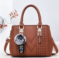Brown litchi leather tote bag with V-stitch design and plush pom-pom charm - Earthy Yellow