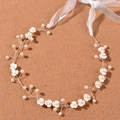Macro detail of bridal headpiece featuring white 3D flowers and pearls on silver wire - Gold
