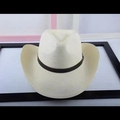 Detail of a beige straw cowboy hat featuring a brown leather band and metal buckle strap - Cream