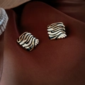 Macro detail of vintage diamond-set rhombus earrings on elegant brown silk fabric - Silver Pin-Black Striped Square Studs