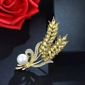 Close-up of golden wheat brooch with yellow stones and a pearl on black surface - Double Wheat Ear Style (X0235)