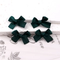 Set of four dark green satin bow hair clips on a textured stone surface display - Dark Green