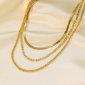 Macro detail of triple-layer 18K gold plated necklaces on soft cream silk fabric - Triple Layer Chain Style (H1104) / Gold