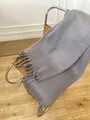 Thick warm mohair style grey scarf with long tassels draped on a modern metal chair - Cream Gray