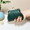 Mini vintage green leather kiss-lock coin purse held in hand for size perspective - Dark Green