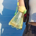 Close-up of 300ml badminton-shaped yellow plastic bottle with green cap and carrying rope - 300ml / Yellow