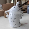 Minimalist white ceramic canister with black spots, lid, and side handles on main view - White