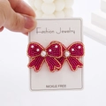 Bohemian bow stud earrings with fuchsia and gold beads and white pearls on a white prop - Rose Red Bow Seed Bead Earrings