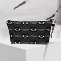 Detail of waterproof Evil Eye makeup bag on white pedestal with lavender decor - 45-Black Abstract Eyes