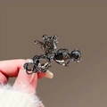 Gunmetal crown and heart hair claw clip with dark crystals held in hand - Crown Crystal Claw