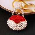 Golden handbag keychain with red rhinestones and white pearls on black background - Red Round Pearl Handbag