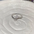 Detalle macro del anillo corazón plateado con circón pavé brillante y acabado metal pulido - Plateado