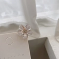Dettaglio di un fermaglio per capelli a fiore con petali glitterati e strass - 1 Pezzo / Bianco