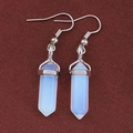 Macro shot of silver hexagonal opal prism dangles on dark textured fabric background - Opal