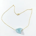 Detail of a light blue raw crystal stone pendant on a delicate gold link chain - Amazonite