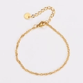 Detalle de una pulsera de cadena trenzada dorada con cierre ajustable y dije redondo - Dorado