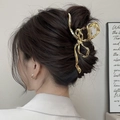 Detail of a large gold butterfly claw clip styled on a brown hair bun for a premium look - Bowknot / 3D Bow / Large / Gold