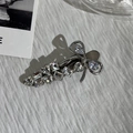 Macro shot of silver metal bow hair clip with sparkling rhinestones on white surface - Clear White