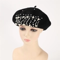Detailed close-up of white pearls and sparkling rhinestones on a black cashmere beret - Black