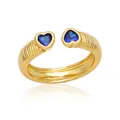 Anello aperto dorato con cristalli a cuore blu e fascia testurizzata su sfondo bianco - Doppio cuore blu intrecciato