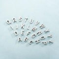 Makroansicht von 26 silbernen Edelstahl-Buchstabenanhängern für DIY-Halsketten - Buchstabe M / Stahlfarbe