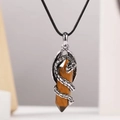 Détail d'un pendentif dragon avec pierre hexagonale brune et finition en métal argenté - Œil de tigre