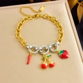 Dettaglio di bracciale a catena dorata con ciondoli a ciliegia e fragola in smalto - Stile Frutta Peperoncino Fragola (B1661)