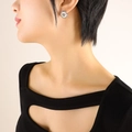 Elegant silver four-leaf clover stud earring with white inlay on female model - Silver Earrings