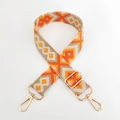 Close-up of geometric embroidered bag strap with golden metal spring hooks and adjusters - Yellow Orange Khaki