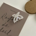 Dettaglio della molletta a farfalla bianco perlato su una copertina di libro vintage - Piccola Pinza a Farfalla