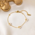 Elegant gold pearl flower bracelet with three floral motifs on white silk background - 3 Pearl Flowers Bracelet Gold