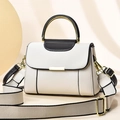 White lychee leather crossbody bag with metal ring handle and contrast piping on a beige stage - Off White