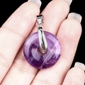 Amethyst donut pendant with silver bail shown on finger for size reference - 20mm Amethyst