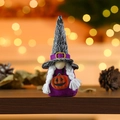 Halloween gnome doll with purple body and witch hat holding a small pumpkin on wood - Pumpkin Pattern