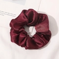 Detail view of wine red silk scrunchie with smooth satin texture and elegant pleats - Burgundy