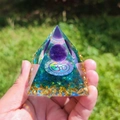 Detailed view of handmade orgone pyramid with amethyst sphere and OM symbol in hand - B-2-1 Amethyst Om Symbol / 5cm