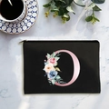 Black canvas cosmetic bag with pink letter O and floral pattern on marble background - Letter O