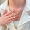 French minimalist gold necklace with pearls, zircon leaves and teardrop pendant on model - Antler Water Drop Style / Gold