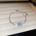Detailed close-up of a vintage silver flower bracelet with blue emerald-cut gemstone - Blue Square Style (HB1455) / Blue