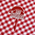 Detail of red and white acrylic Merry Christmas cake topper on a checkered tablecloth - Large Christmas Hat Merry Christmas Insert